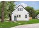 Charming home featuring a stucco exterior, dark trim, and a well-maintained lawn and landscaping at 1502 Burdsal Pkwy, Indianapolis, IN 46208