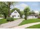 Exterior view of house with a gravel driveway leading to a detached garage and well-kept lawn at 1502 Burdsal Pkwy, Indianapolis, IN 46208