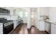Bright kitchen featuring white cabinets, stainless steel appliances, and hardwood floors at 1502 Burdsal Pkwy, Indianapolis, IN 46208
