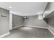 An unfinished basement rec room with recessed lights, painted gray walls, and a door to outside at 1526 Carrollton Ave, Indianapolis, IN 46202