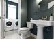 Bathroom with vintage-style sink, modern toilet, and adjacent laundry area at 1526 Carrollton Ave, Indianapolis, IN 46202