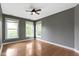 Bedroom featuring hardwood floors, gray walls, a ceiling fan and three windows offering ample natural light at 1526 Carrollton Ave, Indianapolis, IN 46202