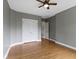 Bedroom with hardwood floors, gray walls, and a large white double-door closet at 1526 Carrollton Ave, Indianapolis, IN 46202