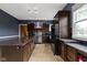 Open kitchen with granite island, stainless steel appliances, and dark wood cabinetry at 1526 Carrollton Ave, Indianapolis, IN 46202