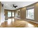Bright living room featuring hardwood floors, neutral walls, large windows, and a ceiling fan for comfort at 1526 Carrollton Ave, Indianapolis, IN 46202