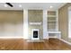 Bright living room featuring hardwood floors, a fireplace with built-ins, and large windows for plenty of natural light at 1526 Carrollton Ave, Indianapolis, IN 46202