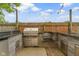 Outdoor kitchen with stainless steel grill, granite countertop and brick patio, perfect for outdoor dining and entertaining at 1526 Carrollton Ave, Indianapolis, IN 46202