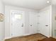 Bright entryway featuring three white doors and modern wood laminate flooring at 1530 Gristmill Meadows Dr, Westfield, IN 46074