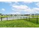 Tranquil pond view with lush green space, black fence, and walking path offering a peaceful setting at 1530 Gristmill Meadows Dr, Westfield, IN 46074