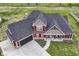 A high angle view of a home with a dark roof, lush lawn, and long driveway at 1595 N Blue Rd, Greenfield, IN 46140