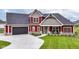 Inviting two-story home showcasing a well-manicured lawn and dark garage doors at 1595 N Blue Rd, Greenfield, IN 46140