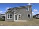 Exterior of the house with tan siding, white trim and windows, and a concrete back patio at 16835 Cheddar Dr, Noblesville, IN 46060