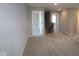 Spacious upstairs hallway with neutral carpeting, light gray walls, and natural light from the door openings at 16835 Cheddar Dr, Noblesville, IN 46060