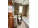 Bathroom with tile flooring, tile walls, white fixtures, and natural wood cabinets at 1739 Crystal St, Anderson, IN 46012