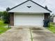 Detached garage with white door and brick siding; features a paved driveway at 1739 Crystal St, Anderson, IN 46012