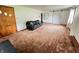 Spacious living room with brown carpet, black couch, white walls, and sliding barn door at 1739 Crystal St, Anderson, IN 46012