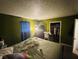 This bedroom features an open closet with a variety of clothes and an olive green paint color at 1809 N Harding St, Indianapolis, IN 46202