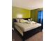 Bedroom with a large bed, green walls, and blue curtains at 1809 N Harding St, Indianapolis, IN 46202