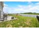 A backyard features a patio with dining set, grill, firepit, lush green lawn, and lake views at 1893 Glenmoor Ct, Columbus, IN 47201