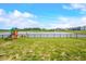 Scenic backyard view with a fence overlooking a peaceful lake with a swing set at 1893 Glenmoor Ct, Columbus, IN 47201