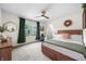 Bright bedroom featuring a wooden bed frame, ceiling fan, and natural light from large window at 1893 Glenmoor Ct, Columbus, IN 47201