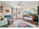 Cozy Bedroom with mountain-themed mural, crib, comfortable chair, and natural light from window at 1893 Glenmoor Ct, Columbus, IN 47201