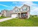 Charming two-story home with a manicured lawn, attached two-car garage, and inviting front porch at 1893 Glenmoor Ct, Columbus, IN 47201