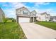 Charming two-story home with a manicured lawn, attached two-car garage, and inviting front porch at 1893 Glenmoor Ct, Columbus, IN 47201