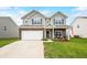 Charming two-story home with a manicured lawn, attached two-car garage, and inviting front porch at 1893 Glenmoor Ct, Columbus, IN 47201