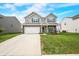 Charming two-story home with a manicured lawn, attached two-car garage, and inviting front porch at 1893 Glenmoor Ct, Columbus, IN 47201