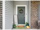 Charming front door with a wreath, decorative plants, and a 'hello' door mat adding a welcoming touch at 1893 Glenmoor Ct, Columbus, IN 47201