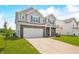 Neat two-story home with attached two-car garage, green lawn, and a welcoming front porch at 1893 Glenmoor Ct, Columbus, IN 47201