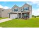 Beautiful home with gray siding, brick accents, a green lawn, and a driveway leading to an attached garage at 1893 Glenmoor Ct, Columbus, IN 47201