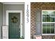 Close-up of the front porch featuring stylish decor, including a wreath, sign, and the house number 1893 at 1893 Glenmoor Ct, Columbus, IN 47201