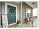 Inviting front porch featuring comfortable seating, potted plants, and a stylish welcome mat at 1893 Glenmoor Ct, Columbus, IN 47201