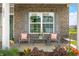 Cozy front porch area with outdoor seating, a small table, and lovely landscaping, creating an inviting space at 1893 Glenmoor Ct, Columbus, IN 47201