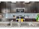 Close-up of the kitchen's granite countertops, stainless steel appliances, and tiled backsplash at 1893 Glenmoor Ct, Columbus, IN 47201