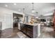 The kitchen boasts dark cabinets, granite countertops, stainless appliances, and an island overlooking the breakfast nook and Gathering room at 1893 Glenmoor Ct, Columbus, IN 47201