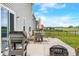 The outdoor patio offers a dining set, grill, firepit, and lush lawn with scenic lake views at 1893 Glenmoor Ct, Columbus, IN 47201