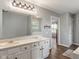 Well-lit bathroom featuring double sinks with cabinet storage, tile flooring, and modern fixtures at 2 E Quail Wood Ln, Westfield, IN 46074