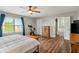 Bright bedroom featuring wood floors, ceiling fan, and attached bathroom with soaking tub at 2 E Quail Wood Ln, Westfield, IN 46074