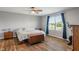 Bright bedroom featuring wood floors, ceiling fan, and large window with natural light at 2 E Quail Wood Ln, Westfield, IN 46074