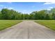 View of the community entrance with grassy areas, a paved road and mature trees at 2 E Quail Wood Ln, Westfield, IN 46074