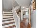 Well-lit staircase with hardwood floors and white railings, leading to the upper level of the home at 2 E Quail Wood Ln, Westfield, IN 46074