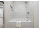 Bright bathroom featuring a soaking tub, a tiled shower, and a wall niche for storage at 2009 Friendship Dr, Indianapolis, IN 46217