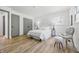 Bright bedroom featuring light wood floors, a white bed with throw pillows, and a charming grey accent chair at 2009 Friendship Dr, Indianapolis, IN 46217