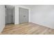 This vacant bedroom includes light wood flooring and grey doors to the closet and entryway to the room at 2009 Friendship Dr, Indianapolis, IN 46217