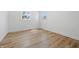 Airy bedroom with wood-look flooring, two windows providing natural light, and fresh white walls at 2009 Friendship Dr, Indianapolis, IN 46217