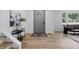 Bright entryway with light wood floors, a decorative rug, and a modern gray door at 2009 Friendship Dr, Indianapolis, IN 46217