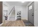 Bright entryway featuring a staircase, modern decor, light wood floors, and a stylish gray door at 2009 Friendship Dr, Indianapolis, IN 46217
